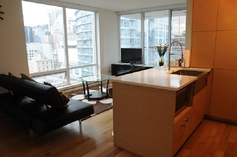 Bright kitchen with hardwood floors and city view, featuring a modern island and sleek cabinetry. - 1405- 565 Smithe Street, Vancouver Downtown
