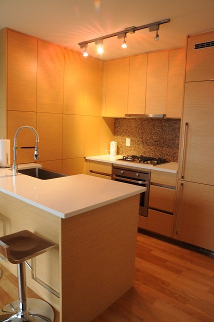 Bright kitchen with modern wood cabinets, white countertops, and hardwood floors. - 1405- 565 Smithe Street, Vancouver Downtown