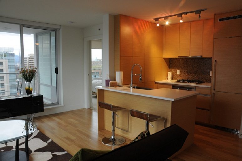 Bright kitchen with wooden cabinets, hardwood floors, and a city view. - 1405- 565 Smithe Street, Vancouver Downtown