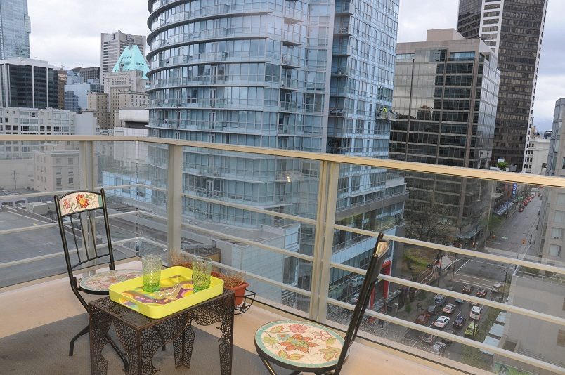 Furnished balcony with city view, modern furnishings, and glass railings. - 1405- 565 Smithe Street, Vancouver Downtown