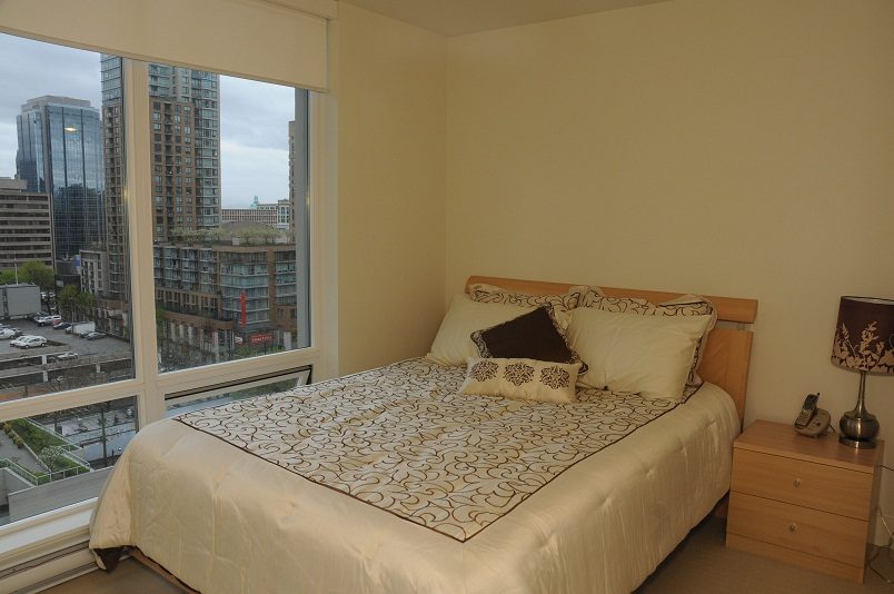 Furnished bedroom with city view and modern decor. - 1405- 565 Smithe Street, Vancouver Downtown