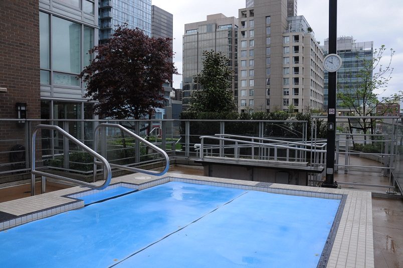 Spacious rooftop terrace with a swimming pool, cityscape views, and modern railings. - 1405- 565 Smithe Street, Vancouver Downtown
