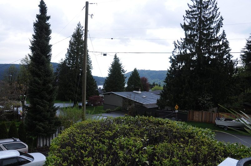 Furnished living room with a view of the water and evergreen trees. - 864 Fairway Drive, North Vancouver