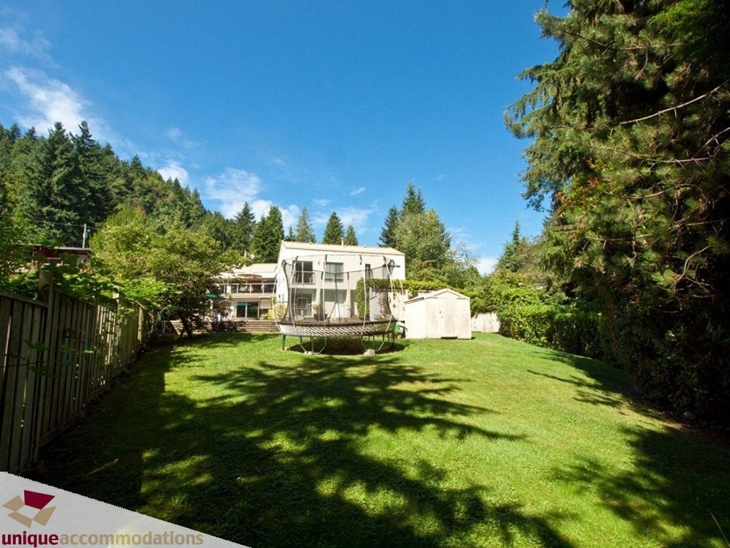 Furnished backyard with grassy lawn and trees, perfect for relaxation. - 750 Anderson Crescent, West Vancouver