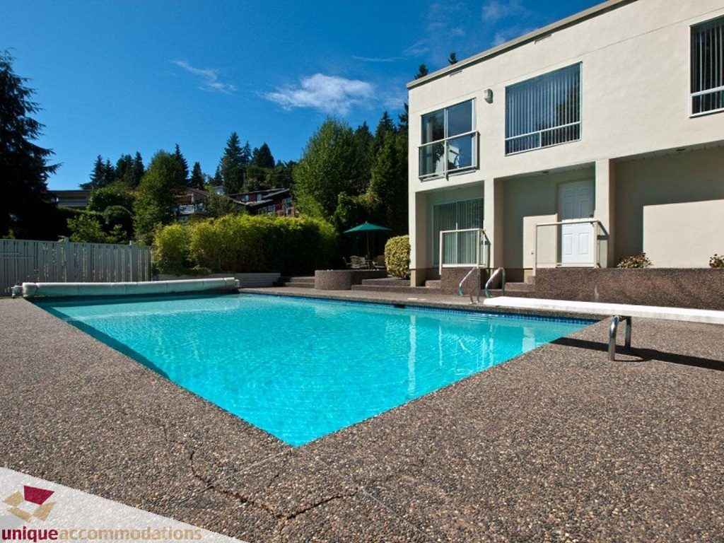 Furnished 4-bedroom + den house with a large, clear blue pool and modern exterior. - 750 Anderson Crescent, West Vancouver