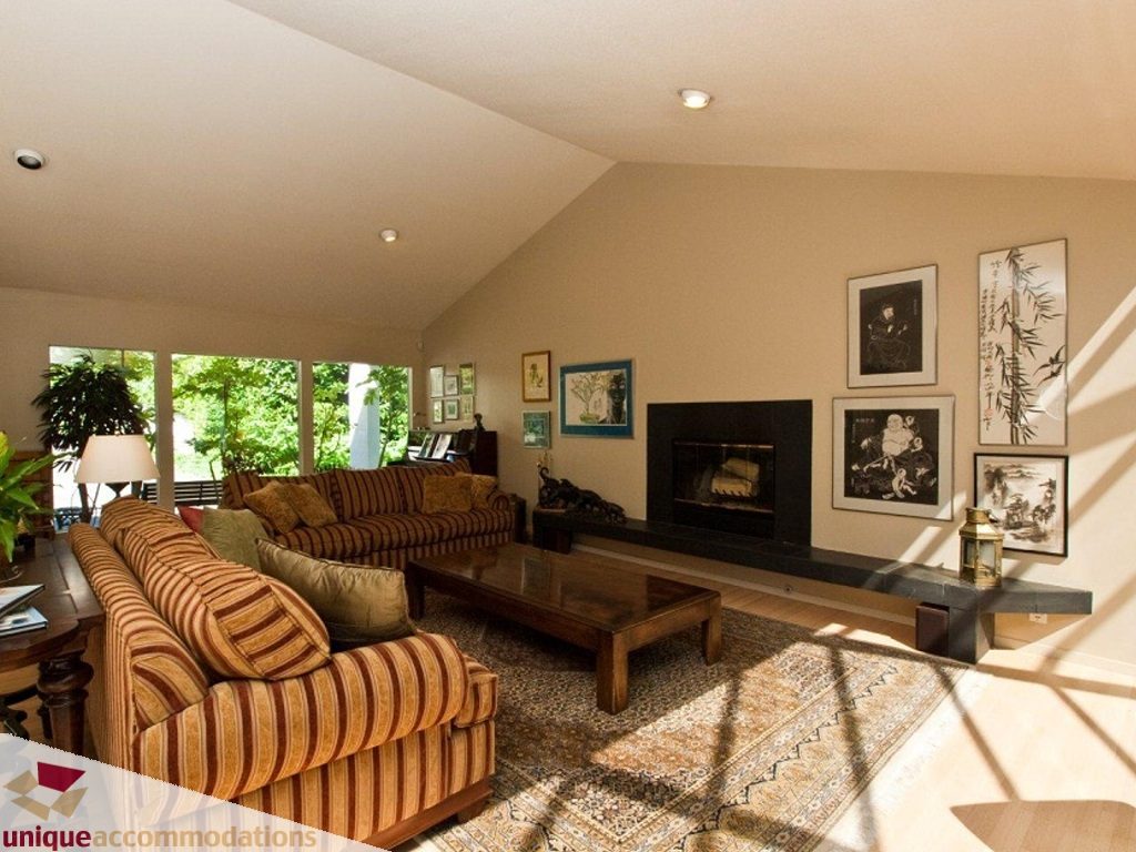 Bright living room with striped furniture, large windows, and gallery wall art. - 750 Anderson Crescent, West Vancouver