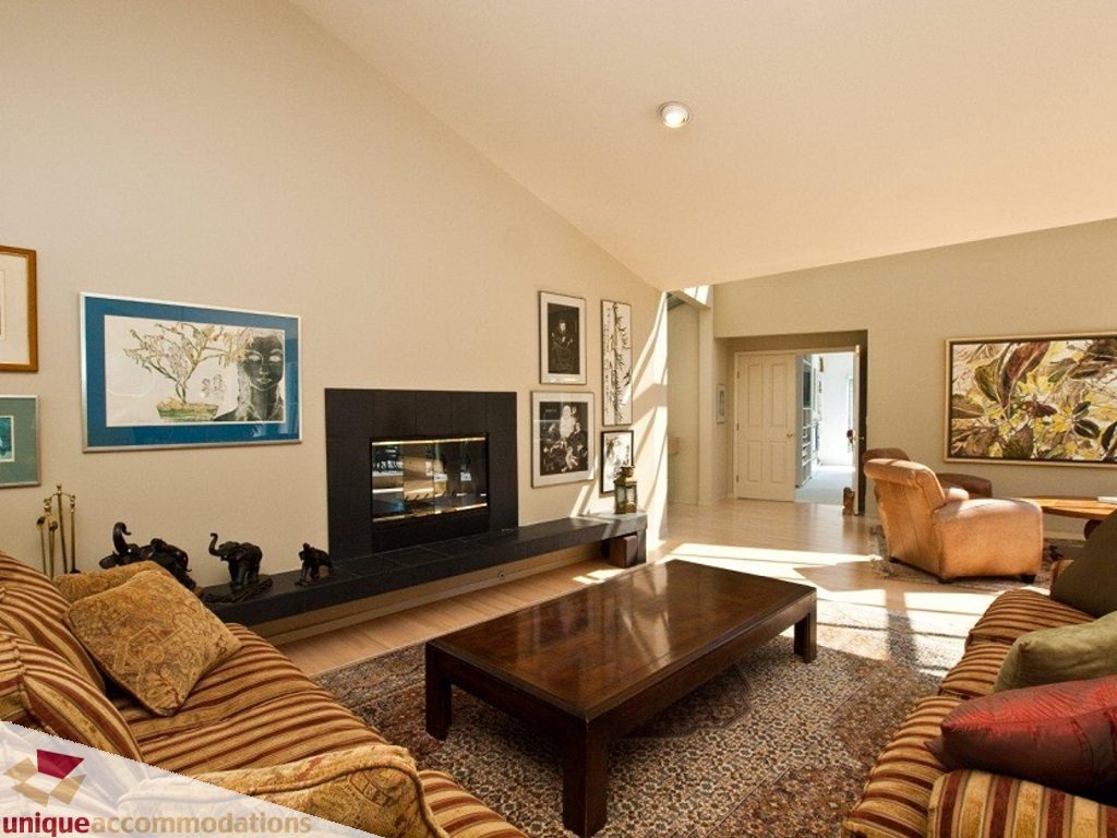 Furnished living room with striped couches, wooden coffee table, and wall art. - 750 Anderson Crescent, West Vancouver