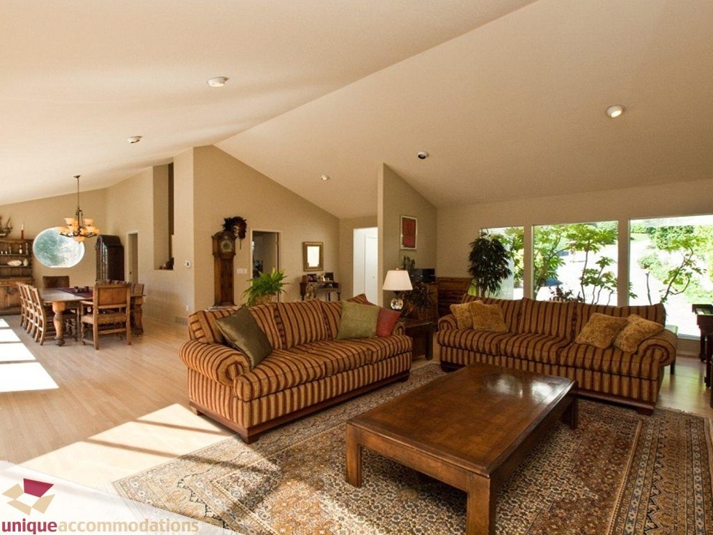 Spacious living room with hardwood floors, striped sofas, and large windows. - 750 Anderson Crescent, West Vancouver