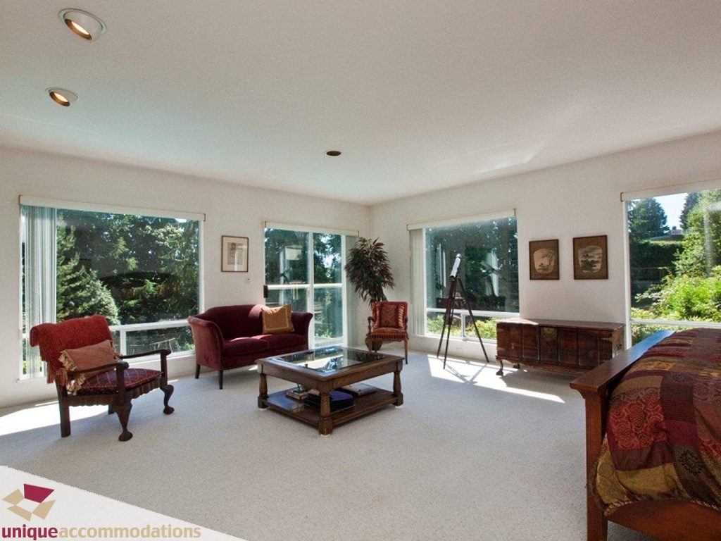 Spacious living room with large windows, carpeted floor, and vintage furniture. - 750 Anderson Crescent, West Vancouver