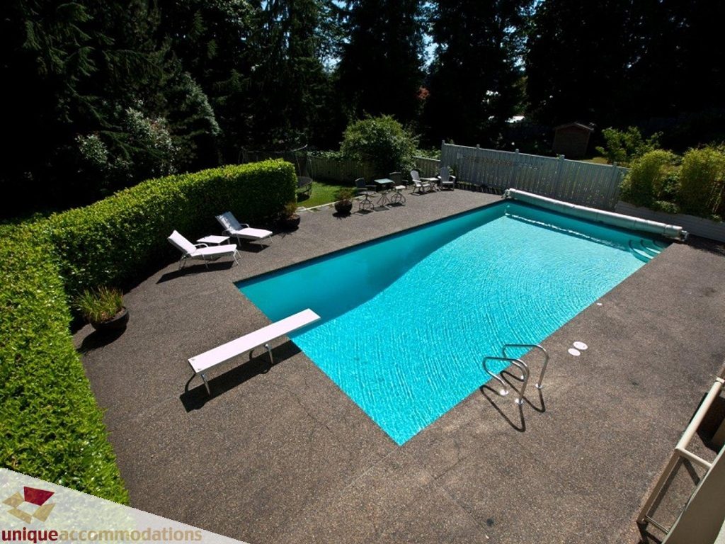 Furnished backyard with a large, inviting pool and lounge chairs. - 750 Anderson Crescent, West Vancouver