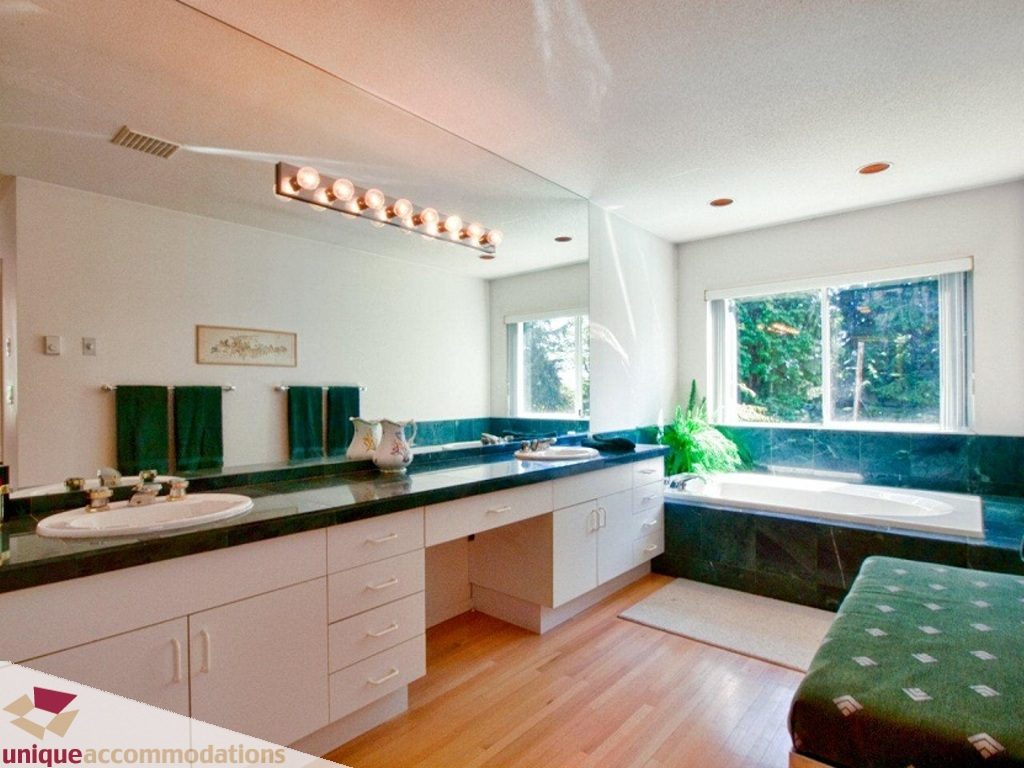 Spacious bathroom with dark green countertops, white cabinets, and hardwood floors. - 750 Anderson Crescent, West Vancouver