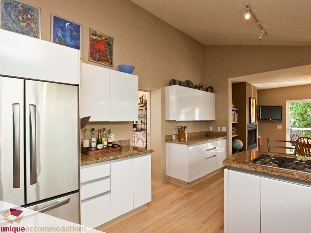 Bright kitchen with white cabinets, granite countertops, hardwood floors, and a city view. - 750 Anderson Crescent, West Vancouver