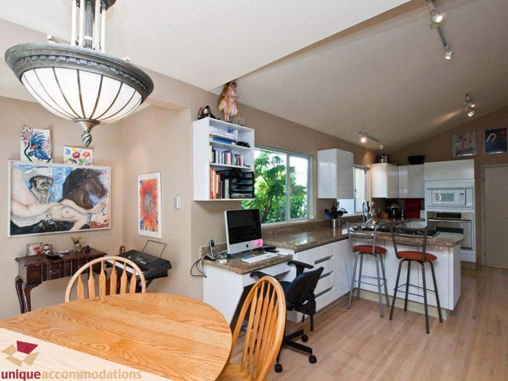 Bright kitchen with granite countertops, hardwood floors, and a dining area with wooden chairs. - 750 Anderson Crescent, West Vancouver