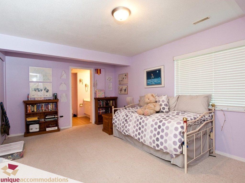 Bright bedroom with purple walls, polka dot bedding, and bookshelves. - 750 Anderson Crescent, West Vancouver