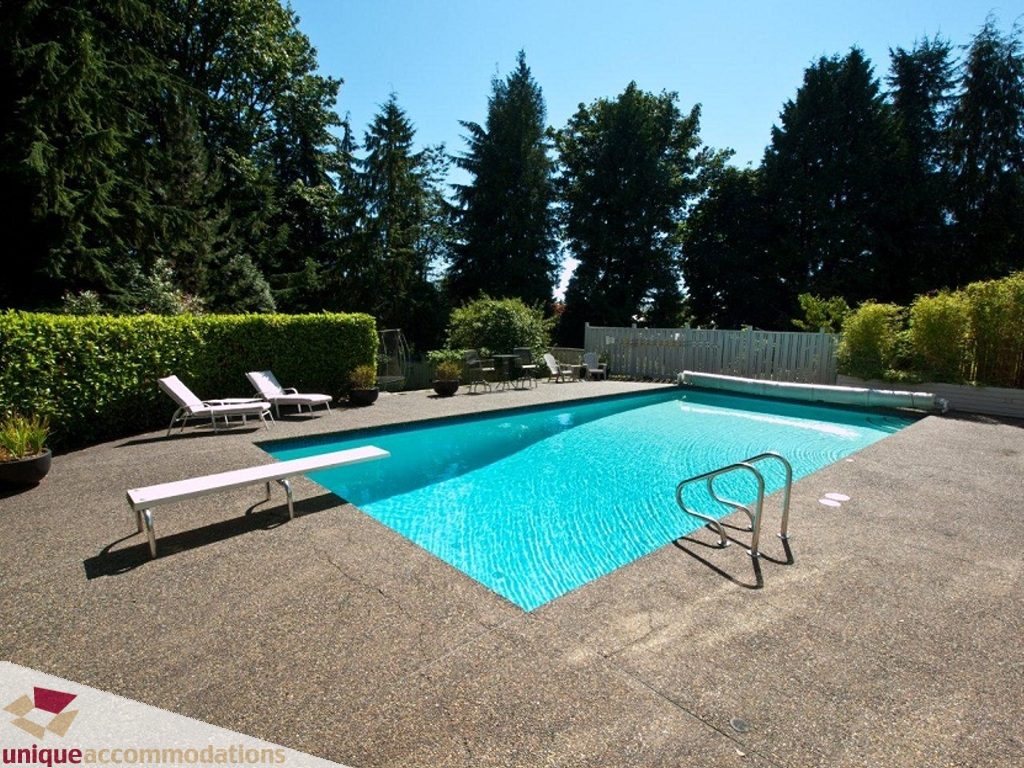 Furnished pool area with lounge chairs and clear blue water. - 750 Anderson Crescent, West Vancouver