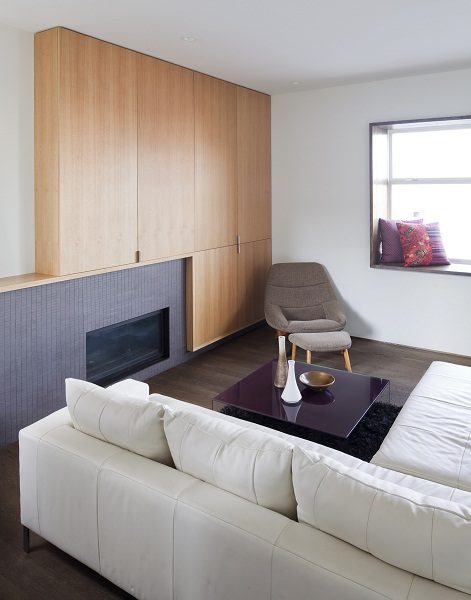 Furnished living room with modern furniture, large window, and wooden accent wall. - 801-233 Abbott Street, Vancouver Downtown