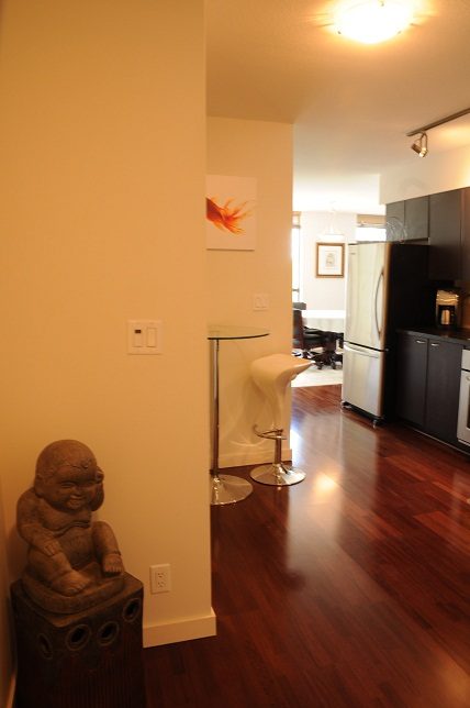 Bright kitchen with hardwood floors, modern appliances, and a cozy corner statue. - 705 - 538 Smithe, Vancouver Downtown