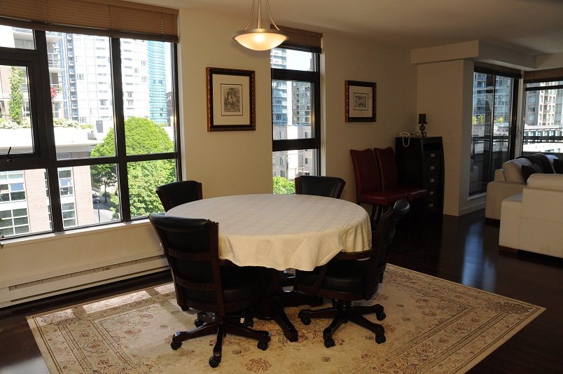 Bright dining area with city view, hardwood floors, and a large round table. - 705 - 538 Smithe, Vancouver Downtown