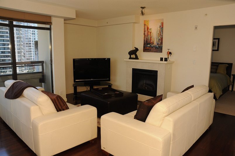 Bright living room with white furniture, city view, and modern decor. - 705 - 538 Smithe, Vancouver Downtown
