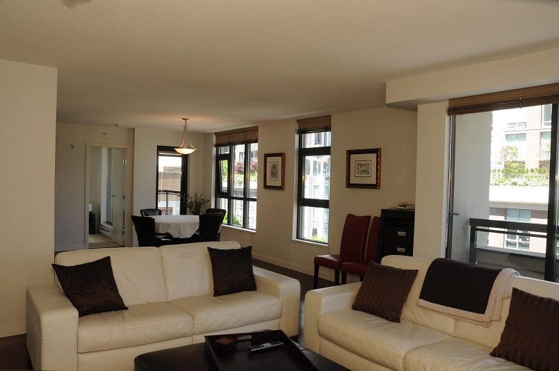 Bright living room with white furniture, large windows, and city view. - 705 - 538 Smithe, Vancouver Downtown