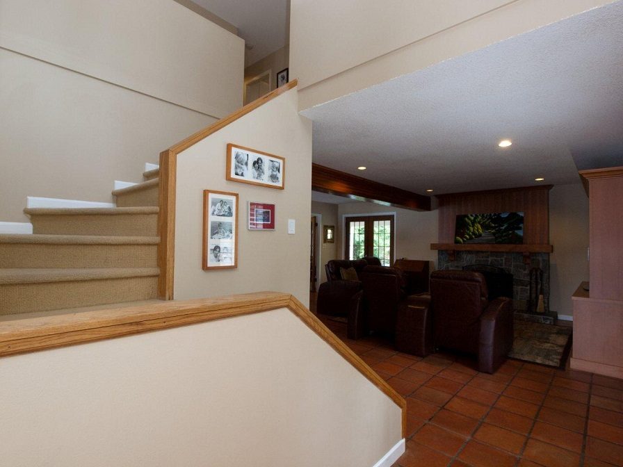 Living room with tiled floor, leather furniture, and fireplace. - 5439 Indian River Drive, North Vancouver