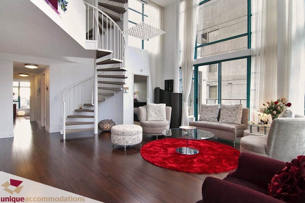 Spacious living room with spiral staircase, hardwood floors, and large windows. - PH-1668 Alberni Street, Vancouver Downtown
