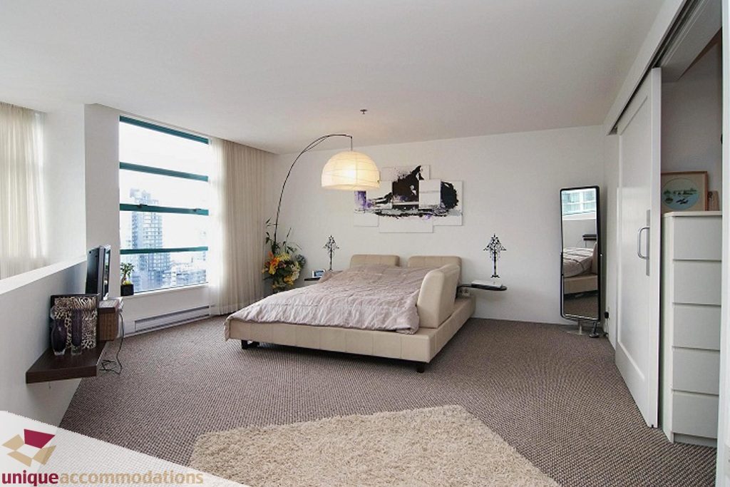 Bright bedroom with large window, city view, modern decor, and plush carpet. - PH-1668 Alberni Street, Vancouver Downtown