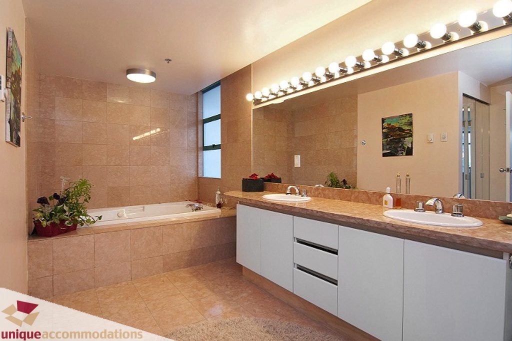 Spacious bathroom with dual sinks, large mirror, and tiled walls. - PH-1668 Alberni Street, Vancouver Downtown
