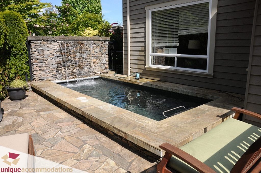 Furnished patio with stone water feature and seating area. - 3035 Newmarket Drive, North Vancouver