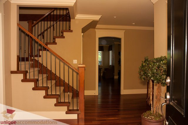 Foyer with wooden staircase, hardwood floors, and modern decor. - 3035 Newmarket Drive, North Vancouver