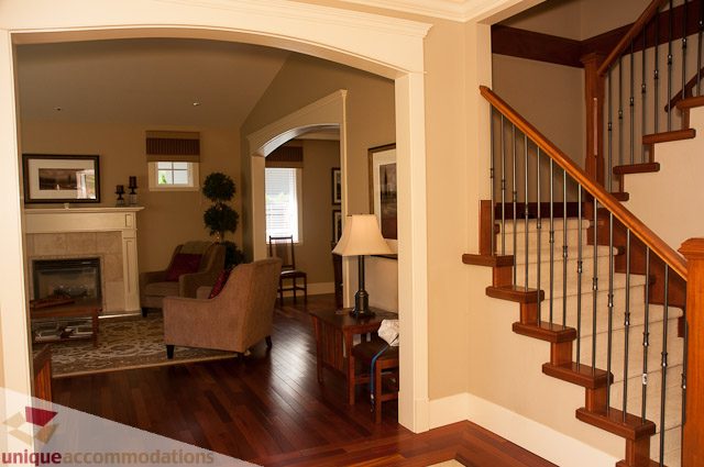 Furnished living room with hardwood floors and a cozy fireplace. - 3035 Newmarket Drive, North Vancouver