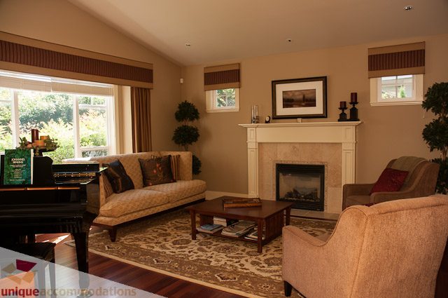 Furnished living room with fireplace, large windows, and comfortable seating. - 3035 Newmarket Drive, North Vancouver
