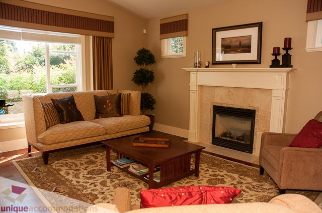 Spacious living room with fireplace, large windows, and cozy furniture. - 3035 Newmarket Drive, North Vancouver