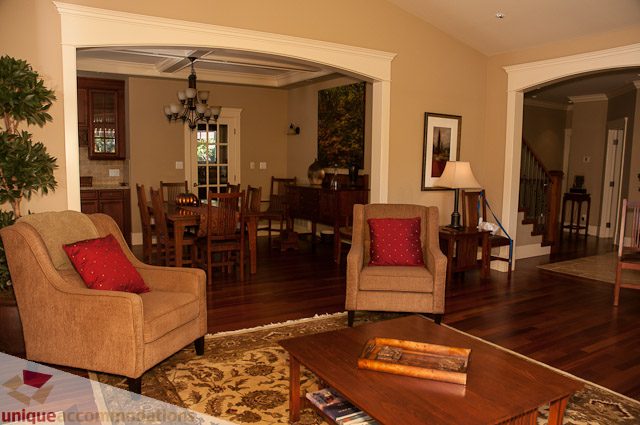 Furnished living room with hardwood floors and a dining area in the background. - 3035 Newmarket Drive, North Vancouver
