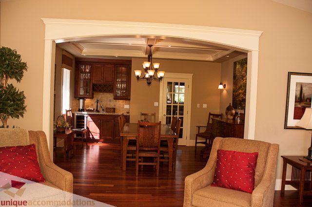 Furnished living room with hardwood floors and a view into the kitchen. - 3035 Newmarket Drive, North Vancouver