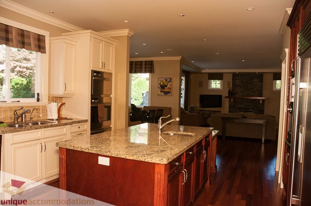 Bright kitchen with granite countertops, hardwood floors, and a city view. - 3035 Newmarket Drive, North Vancouver