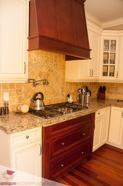 Bright kitchen with granite countertops, hardwood floors, and a wooden hood. - 3035 Newmarket Drive, North Vancouver