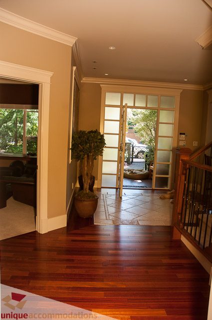 Foyer with hardwood floors, glass doors leading to garden, modern decor. - 3035 Newmarket Drive, North Vancouver