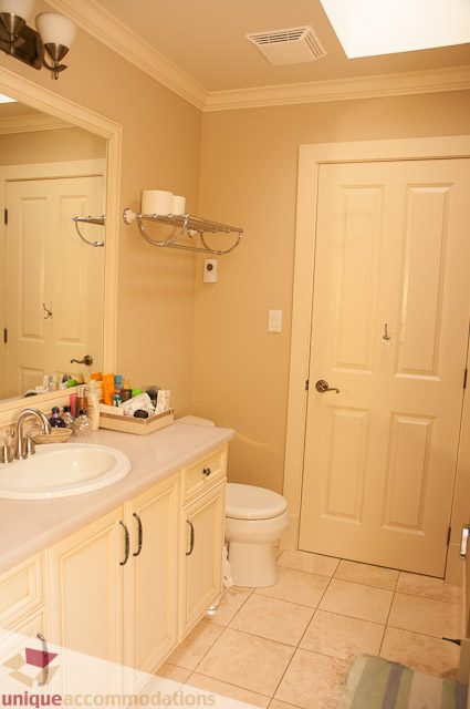 Bright bathroom with white vanity, beige walls, and a walk-in shower. - 3035 Newmarket Drive, North Vancouver