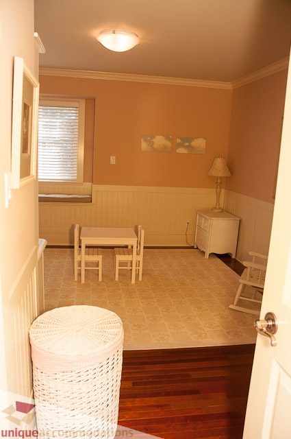 Bright dining area with wooden floors and a small table for four, featuring a lamp and artwork on the wall. - 3035 Newmarket Drive, North Vancouver