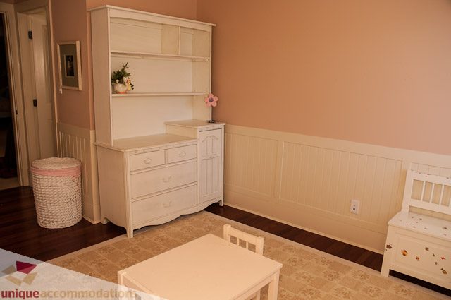 Bright dining room with white cabinets, hardwood floors, and a floral centerpiece. - 3035 Newmarket Drive, North Vancouver
