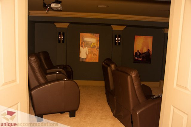 Luxurious home theater with leather recliners and movie posters. - 3035 Newmarket Drive, North Vancouver
