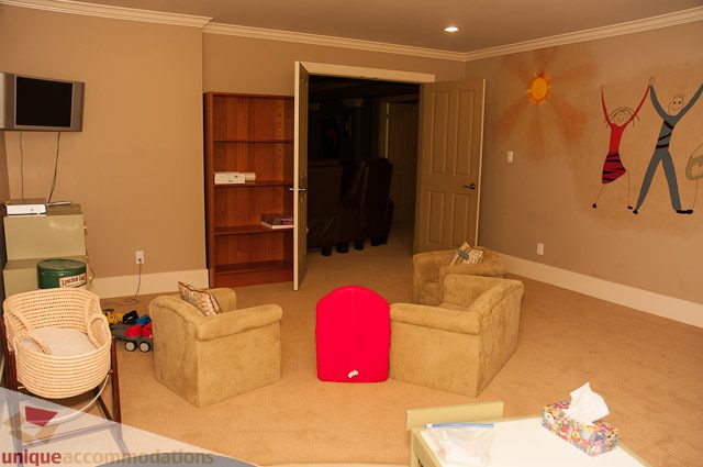 Furnished living room with colorful wall art and a cozy seating area. - 3035 Newmarket Drive, North Vancouver