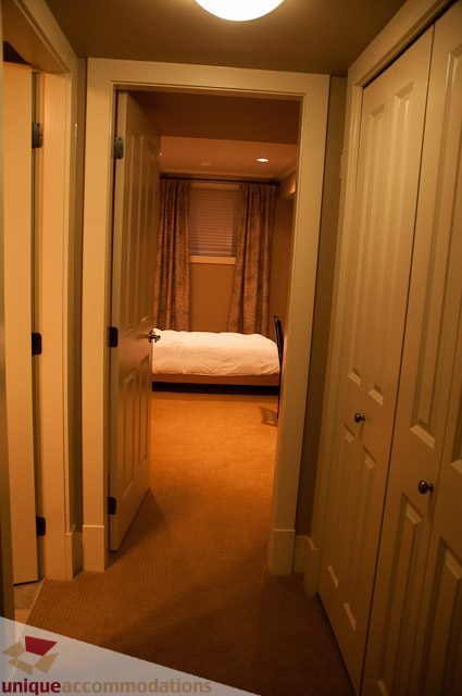 Furnished bedroom with neatly made bed and patterned curtains. - 3035 Newmarket Drive, North Vancouver