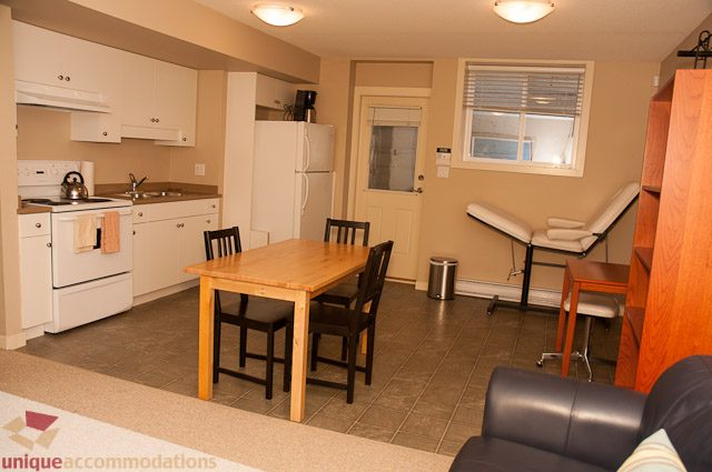 Bright kitchen with white cabinets, granite countertops, and hardwood floors. - 3035 Newmarket Drive, North Vancouver