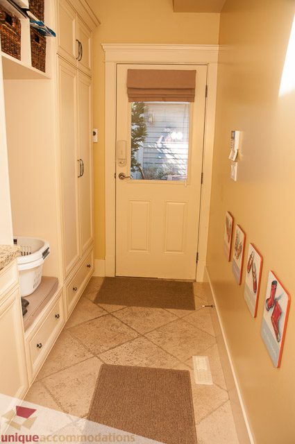 Foyer with tiled floors, wooden cabinets, and framed artwork. - 3035 Newmarket Drive, North Vancouver