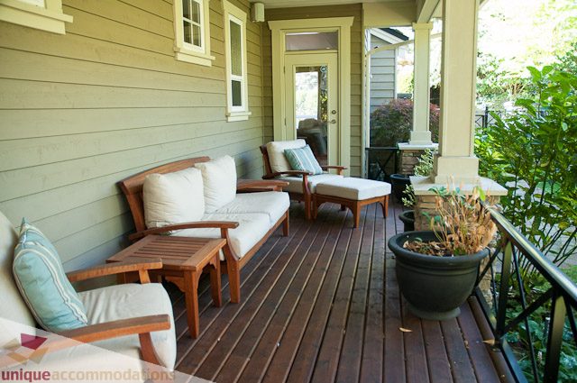 Furnished porch with wooden furniture, plants, and a view of the garden. - 3035 Newmarket Drive, North Vancouver
