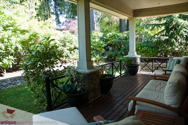 Furnished living room with cozy seating and lush garden view. - 3035 Newmarket Drive, North Vancouver