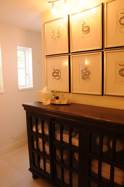 Framed snake illustrations on wall above dark wood console table with decorative items. - Main House - 440 Stevens Drive, West Vancouver