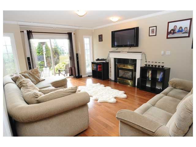 Spacious living room with hardwood floors, large sectional sofa, and a fireplace. - 1889  Alderlynn Drive, North Vancouver